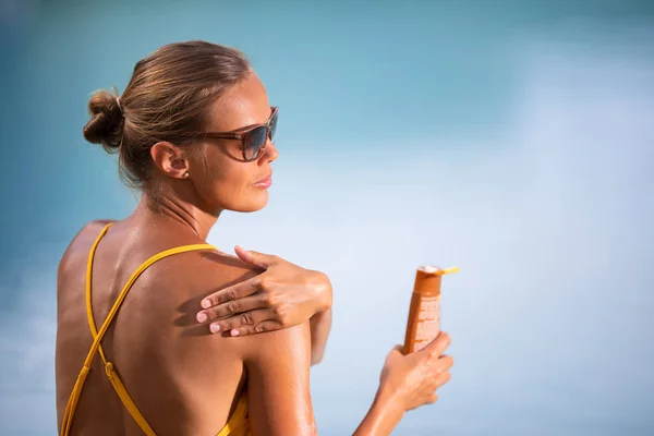 Suncream のコンセプトです かなり 水着姿の若い女性がしようと彼女を愛している日光の有害な影響から肌を守る日焼け止めを適用します — ストック写真