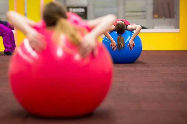 フィットネス トレーニングで Gymball を持つ若い女性でピラティスのクラスの人をグループ化 被写し界深度の浅い 色のトーンのイメージ — ストック写真