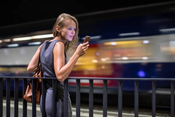 漂亮的年轻女性通勤者在现代火车上等着她的每日火车 一边等一边用手机 彩色调音图像 — 图库照片