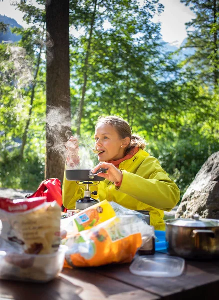 女徒步者 登山者准备在营地的燃气燃烧器上吃晚饭 — 图库照片