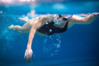 Kapalı bir yüzme havuzunda kadın yüzücü - emekleme (sığ DOF)