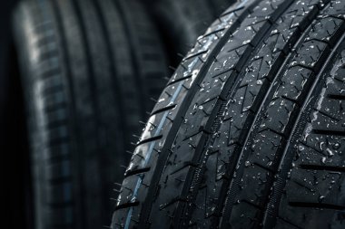 Yepyeni yüksek performanslı araba lastikleri temiz, beyaz stüdyo arka planında.