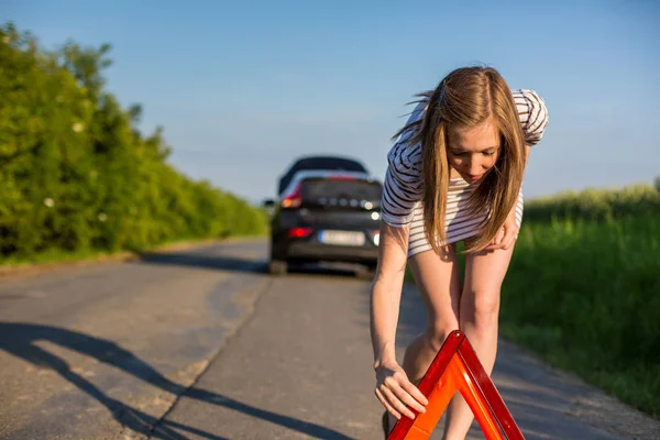 かなり 若い女性の彼女の車が壊れた後 道端で安全三角形を設定 — ストック写真