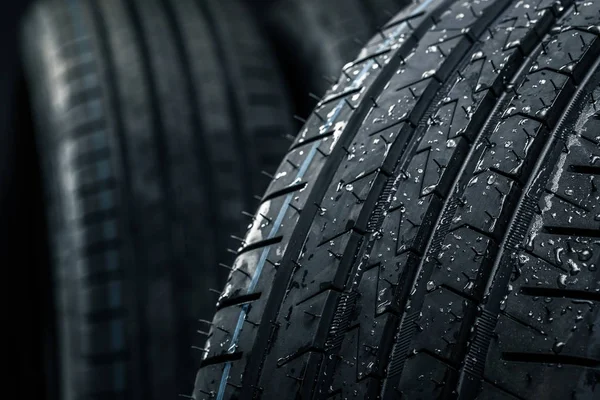 Yepyeni yüksek performanslı araba lastikleri temiz, beyaz stüdyo arka planında.