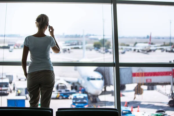 Güzel genç bayan bir geçit alanı için insanları arıyor çağrı - modern bir Havalimanı bekliyor (Renk tonlu görüntü; sığ Dof)