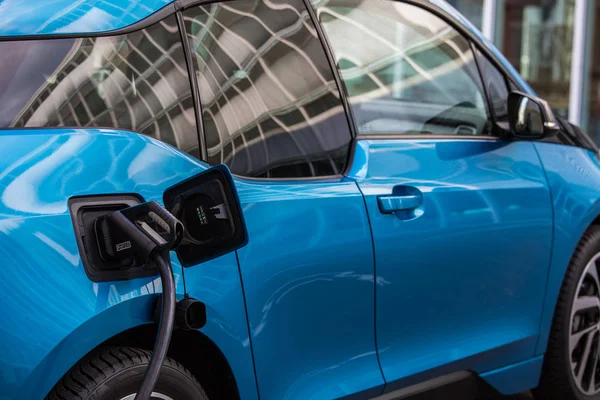 Elektrikli araba şarjı için güç kaynağı. Elektrikli araba şarj istasyonu. Şarj edilen bir elektrikli arabaya takılan güç kaynağını kapatın..