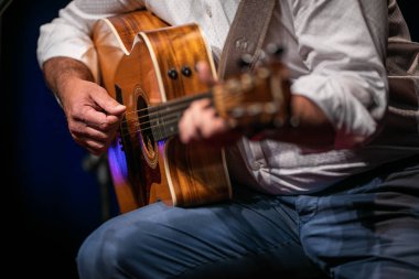 Sahnede gitar çalan adam (sığ DOF; renk tonlu resim)