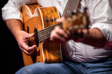Sahnede gitar çalan adam (sığ DOF; renk tonlu resim)