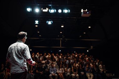 Sözcü kurumsal İş Konferansı hakkında bir konuşma yapacak. Konferans salonundaki izleyiciler. İş ve Girişimcilik etkinliği.