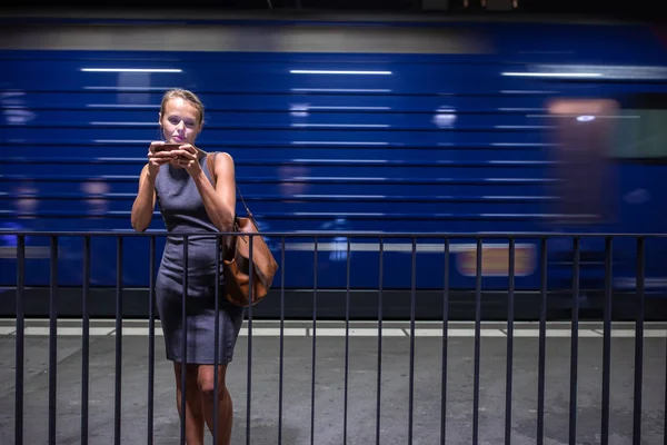 아름답고 통근자가 현대적 역에서 기차를 기다리고 있습니다 기다리는 핸드폰을 사용하고 — 스톡 사진