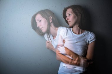 Young woman suffering from a severe depression/anxiety (color toned image; double exposure technique is used to convey the mood of unease, progression of the anxiety/depression) clipart