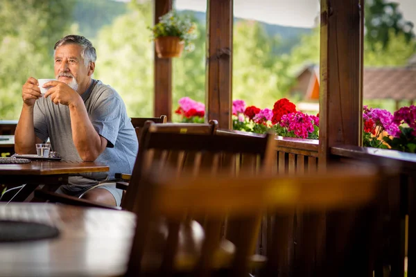 山のホテルのテラス 休暇中に彼の朝のコーヒーを楽しんでいるハンサムな年配の男性 — ストック写真