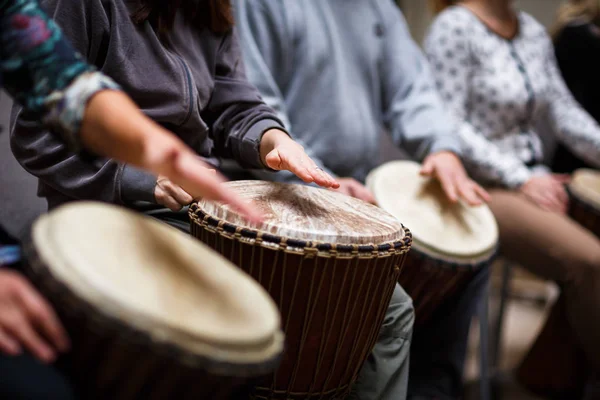 Group of people playing on drums - therapy by music