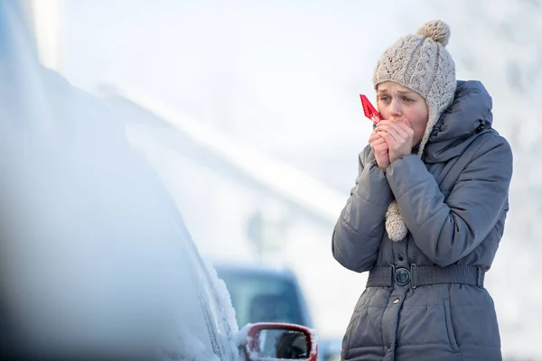 在一个冬天的早晨 清洗她的车从雪和霜的年轻女子她冻结 需要去上班 — 图库照片