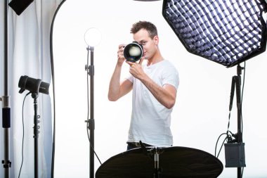 Fotoğraf çekmek genç pro fotoğrafçı ile dijital fotoğraf makinesi - Dslr ve onun iyi donanımlı Studio büyük bir telefoto lens (Renk tonlu görüntü; sığ Dof)