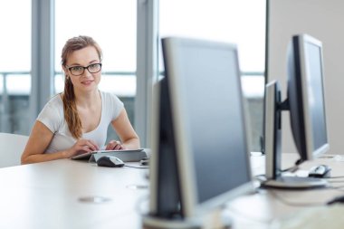 Güzel, bir çalışma odası / ofis / ofis / okul konseptinde tablet bilgisayarını kullanan kız öğrenci (renk tonlu resim; sığ DOF)