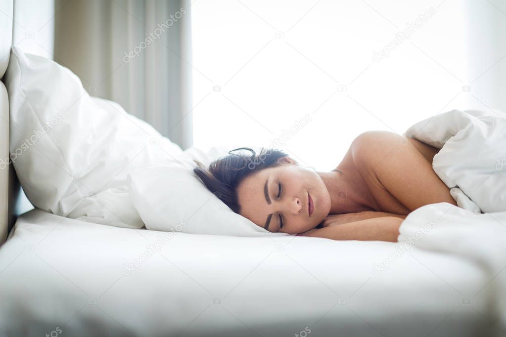 Beautiful young woman sleeping on bed at bedroom