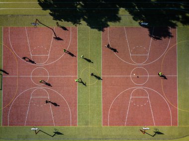 Futbol oynarken o - sıcak sabah güneşi, döküm uzun gölgeler içinde insanlarla bir futbol sahası havadan görünümü