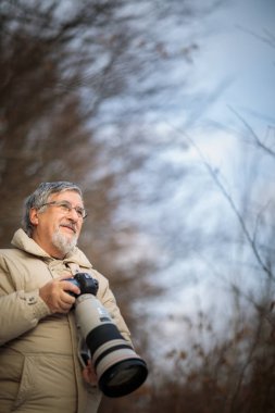 Son sınıf öğrencisi zamanını en sevdiği hobisine harcıyor: Fotoğrafçılık - dijital kamerası / DSLR ve büyük bir telefoto lensi ile dışarıda fotoğraf çekiyor.