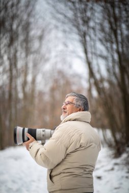 Son sınıf öğrencisi zamanını en sevdiği hobisine harcıyor: Fotoğrafçılık - dijital kamerası / DSLR ve büyük bir telefoto lensi ile dışarıda fotoğraf çekiyor.