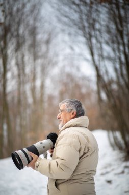 Son sınıf öğrencisi zamanını en sevdiği hobisine harcıyor: Fotoğrafçılık - dijital kamerası / DSLR ve büyük bir telefoto lensi ile dışarıda fotoğraf çekiyor.