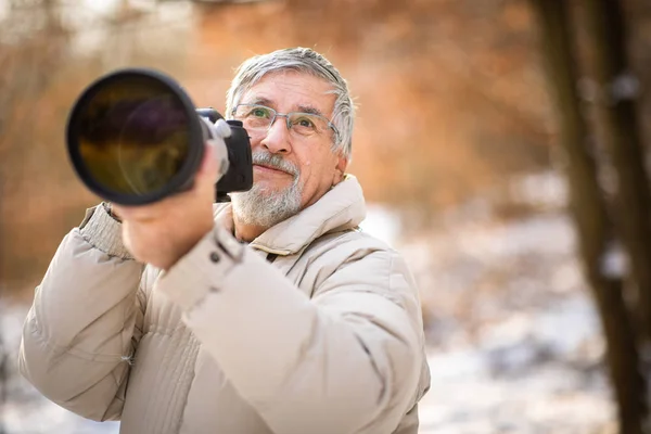 趣味に時間を費やすシニア男性 デジタルカメラ デジタル一眼レフと大きな望遠レンズで屋外で写真を撮る — ストック写真