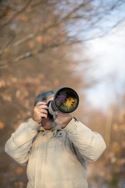 趣味に時間を費やすシニア男性 デジタルカメラ デジタル一眼レフと大きな望遠レンズで屋外で写真を撮る — ストック写真