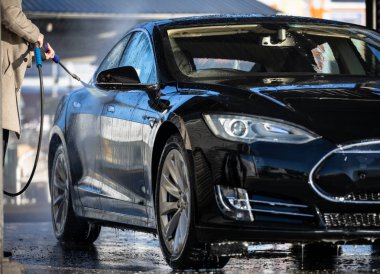 Sevimli kadın arabasına el ile bir carwash yıkama (Renk tonlu görüntü)