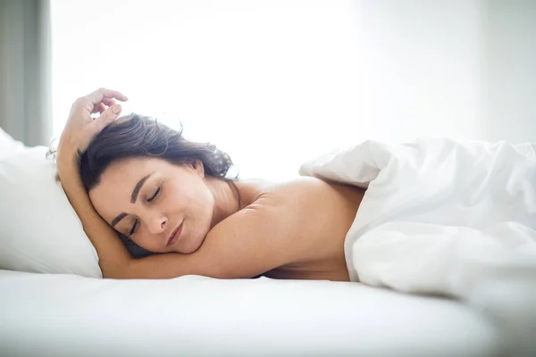 Красива молода жінка спить у ліжку — стокове фото