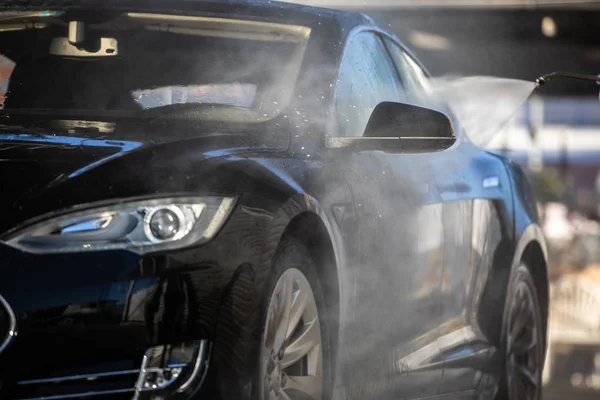 Mujer lavando su coche en un lavado manual de coches — Foto de Stock