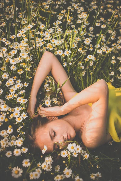 A virágok közepette fekve fiatal nő portréja — Stock Fotó