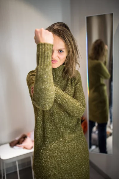 Jonge vrouw gelukkig winkelen in een mode winkel, proberen op een aantal — Stockfoto