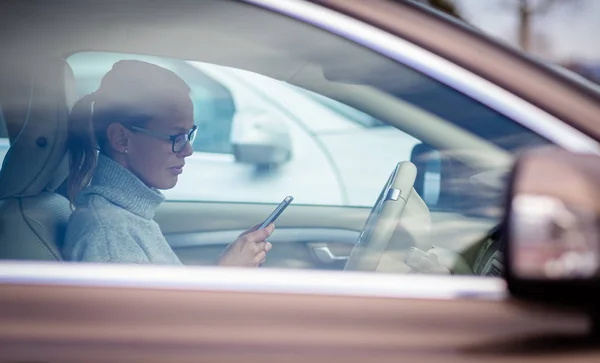 Mooie, jonge vrouw die de nodige parkeer klok achter de voorruit zet — Stockfoto