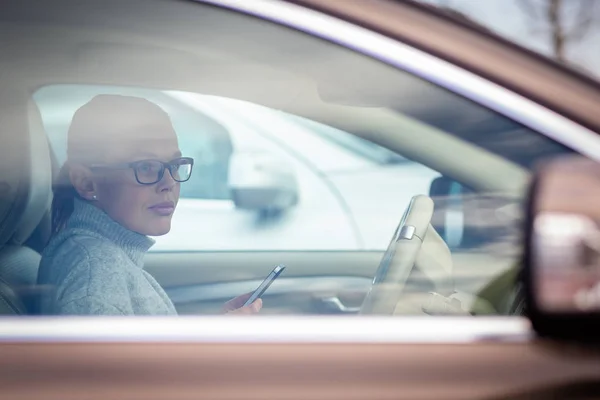 Mooie, jonge vrouw die de nodige parkeer klok achter de voorruit zet — Stockfoto