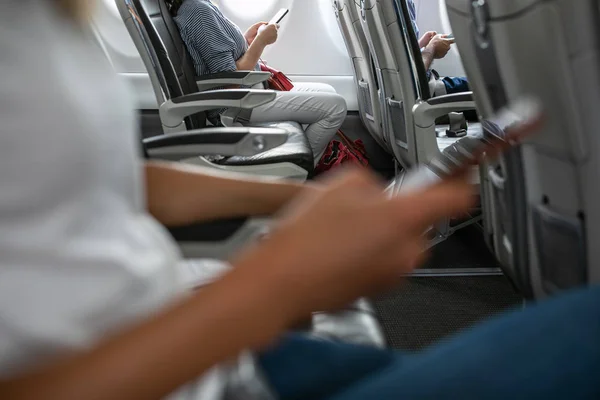 Passangers in abord een commerciële vlucht met behulp van hun mobiele telefoons — Stockfoto