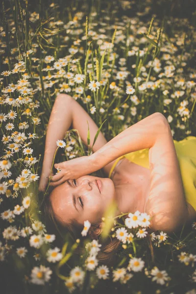 Portrait of young  woman lying down amid flowers — Stock Photo, Image