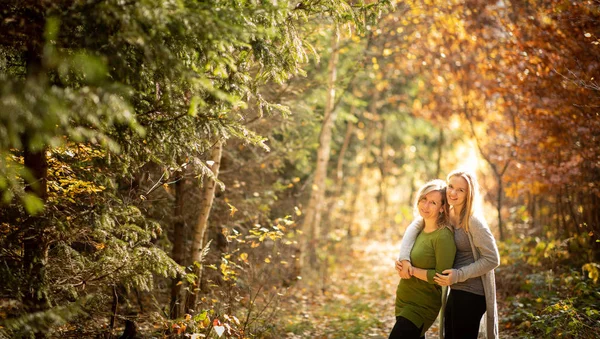 Madre e hija en el hermoso bosque otoñal — Foto de Stock