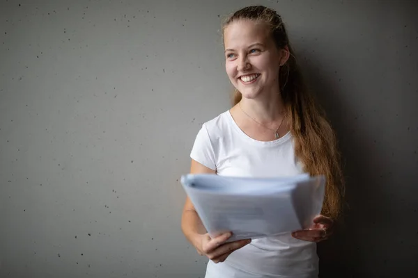 Söt kvinnlig högskola / gymnasieelev med böcker i biblioteket — Stockfoto