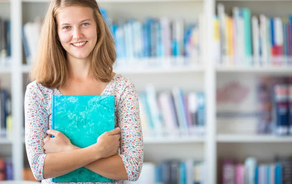 Cute female university/highschool student with books in library — Stock Photo, Image