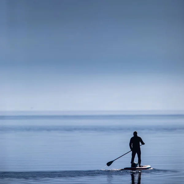 Homem em um stand up padlle board em um lago — Fotografia de Stock