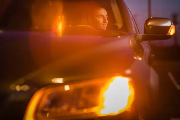 Csinos fiatalember vezetési kocsiját éjjel (színes tónusú kép) — Stock Fotó
