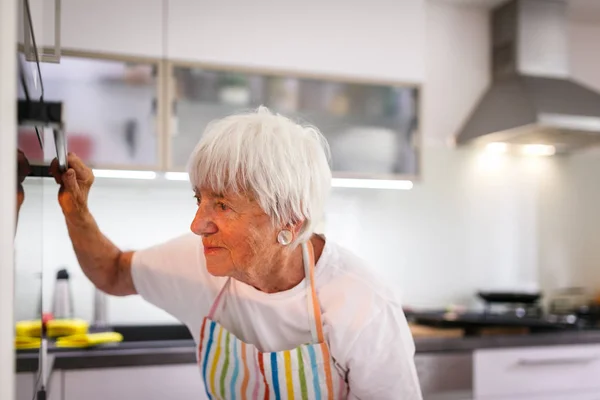 Donna anziana che cucina in cucina — Foto Stock