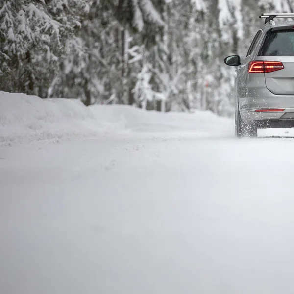 Coche en un camino nevado de invierno en medio de bosques —  Fotos de Stock