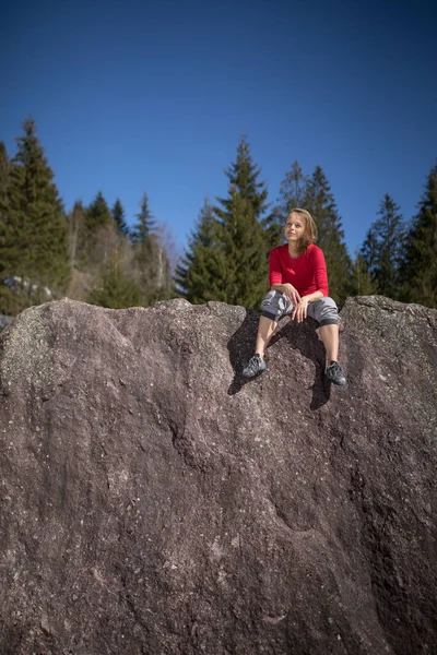 年轻的女登山者爬到外面的天然巨石顶上 — 图库照片