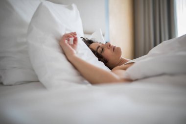 Yatak odası, yatakta uyuyan güzel genç kadın