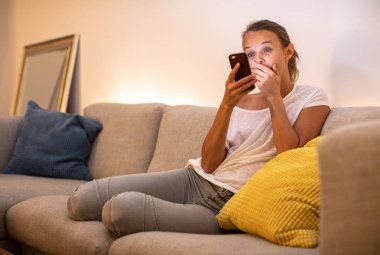 Onu modern dairede rahat bir kanepede sevimli genç kadın