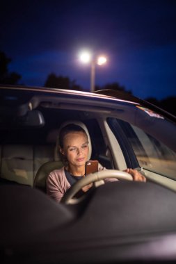 Genç kadın sürücü onu cep telefonu ile oynuyor 
