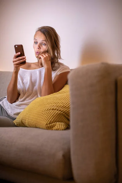 Söt ung kvinna på en bekväm soffa i sin moderna lägenhet — Stockfoto