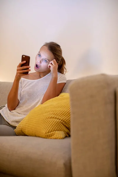 Söt ung kvinna på en bekväm soffa i sin moderna lägenhet — Stockfoto