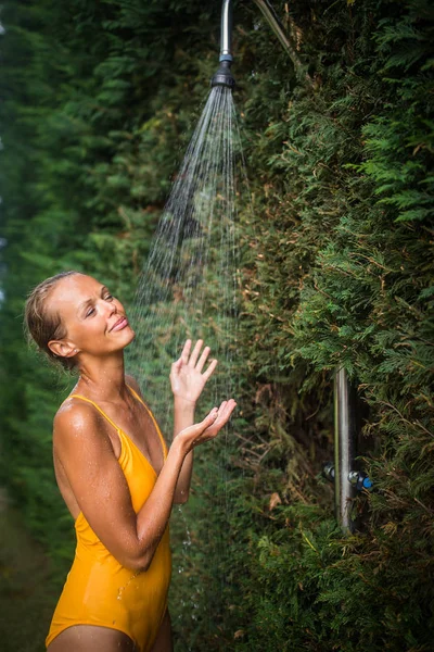 Hermosa mujer joven tomando una ducha al aire libre —  Fotos de Stock
